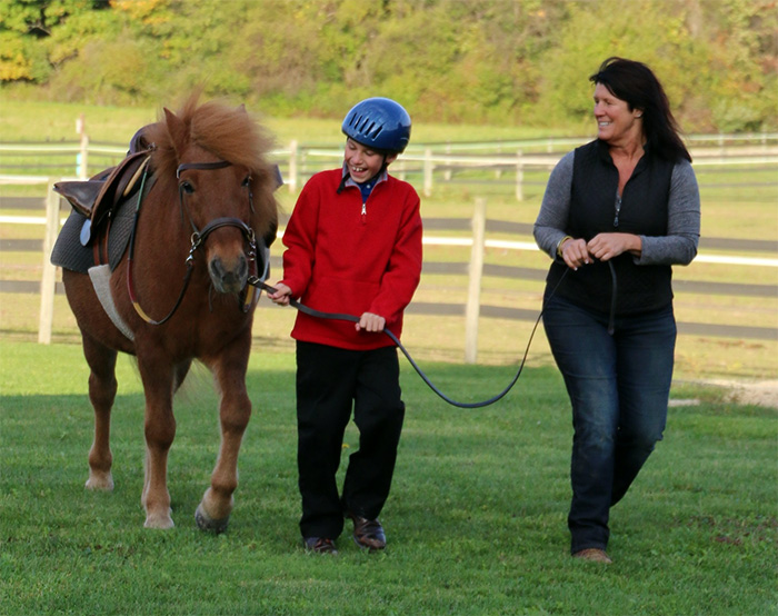 Fieldstone farm volunteer with student and horse