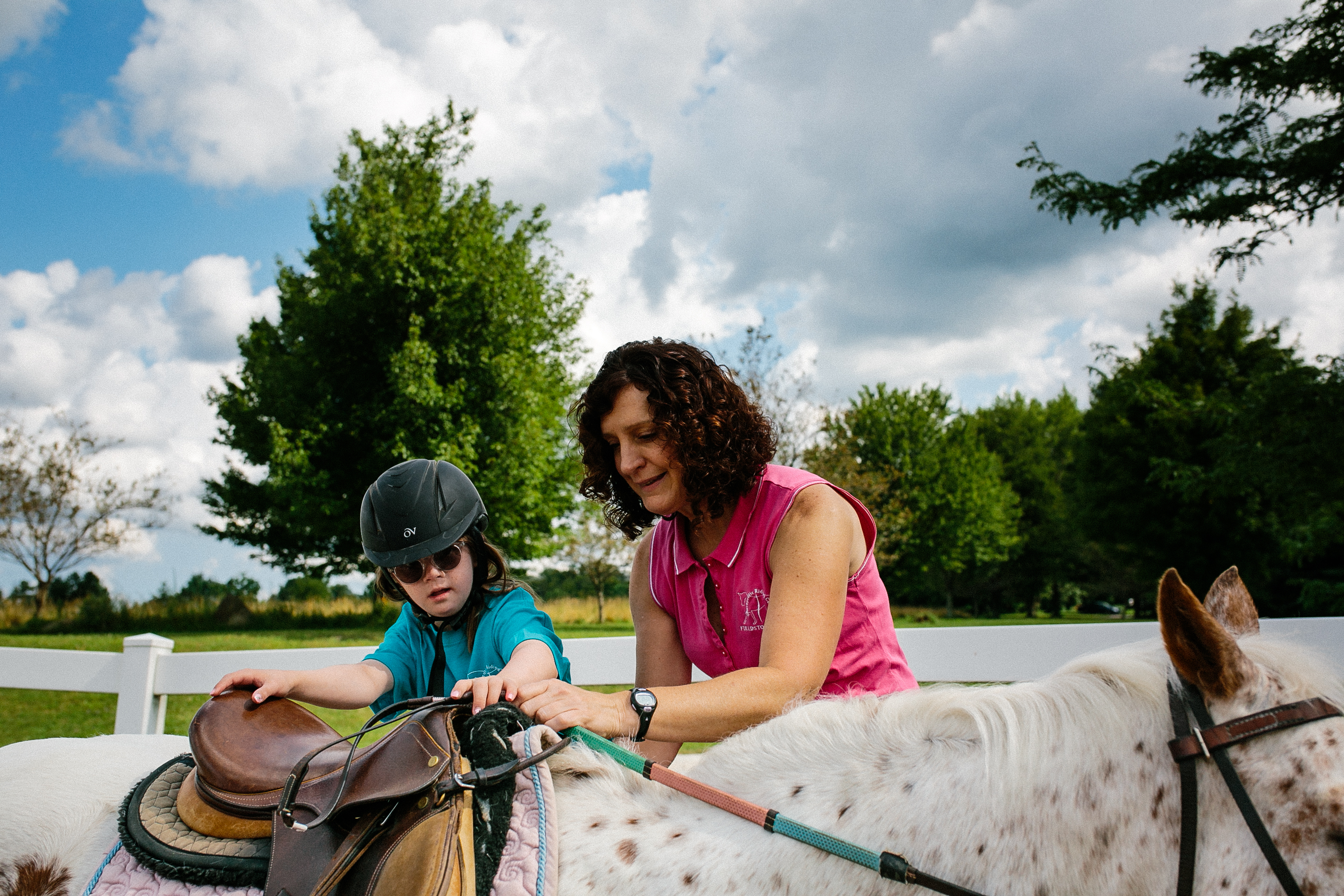 Student climbing into the saddle with an instructor's help