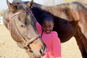 Tessa petting a horse's head