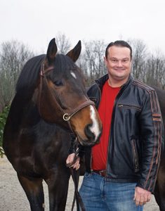 Tom Murphy standing with a horse