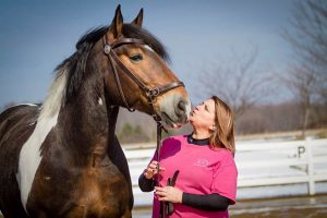 Beth looking up at a horse's face