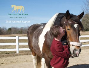 Cover photo of the 2024 annual report, a student standing with a horse